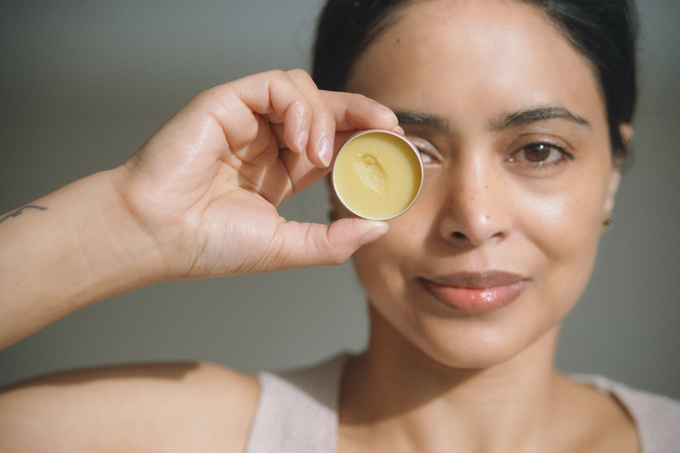 An open tin of the Universal Balm, held up to the light